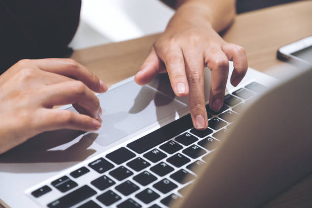 istock Closeup image of hands working and typing on laptop keyboard with blur background 960772626