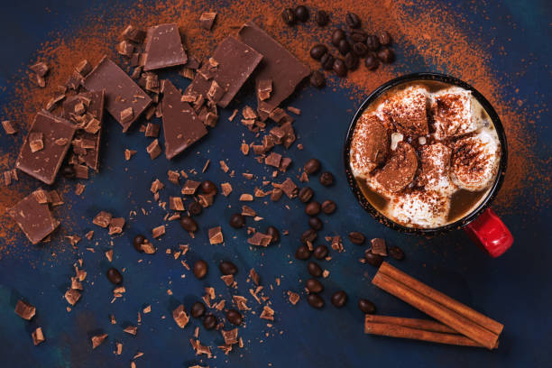 istock Hot chocolate in a mug with marshmallows and chocolate slices on a blue background. Top view, selective focus. Copy space. Flat lay 960773250