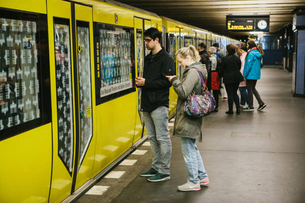 the berlin underground. people stand on the platform and wait for the train. - clock station people berlin germany imagens e fotografias de stock