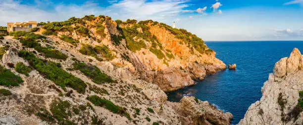 Idyllic view of Lighthouse in Cala Ratjada at the rough cliff coast on Mallorca island, Spain