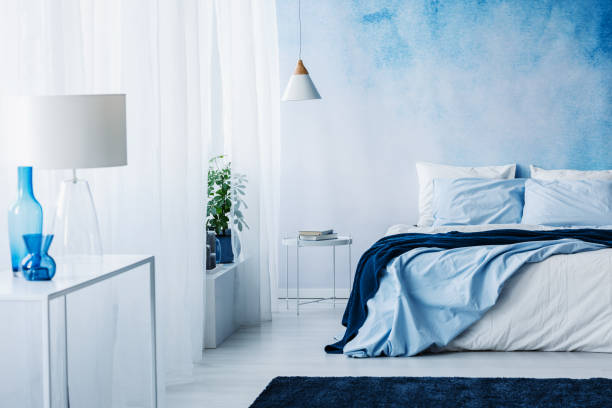 istock Relaxing bedroom interior with white and blue decorations, double bed and wallpaper 960834146
