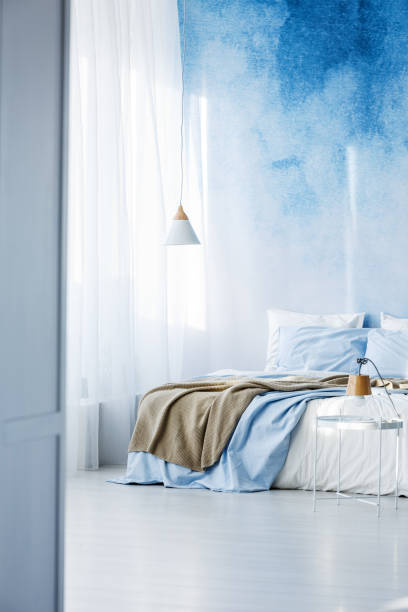 istock Bright bedroom interior with double bed, beige blanket and ombre wall 960834152