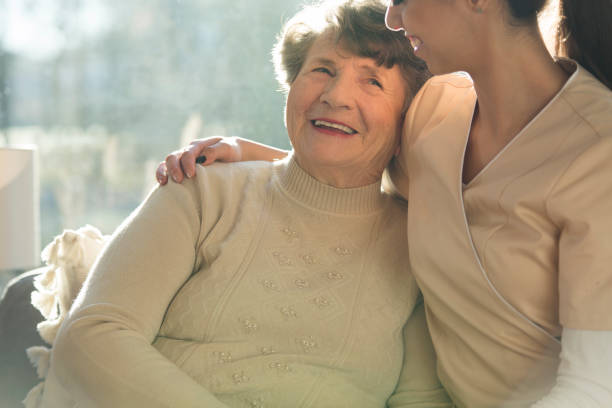 istock Caregiver hugging smiling senior woman 960834898