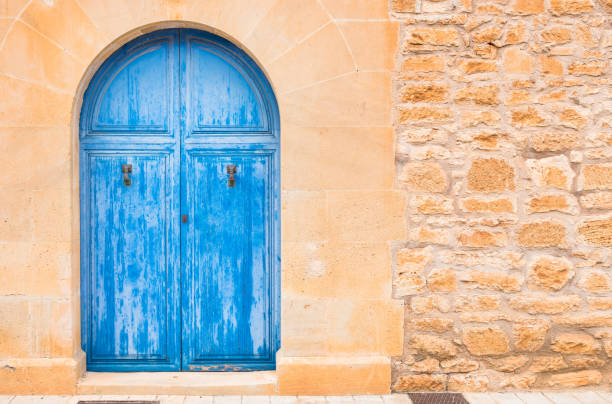 Blue wooden front door and stone wall of mediterranean house Detail view of mediterranean house blue wooden door and stone wall background rustic door stock pictures, royalty-free photos & images