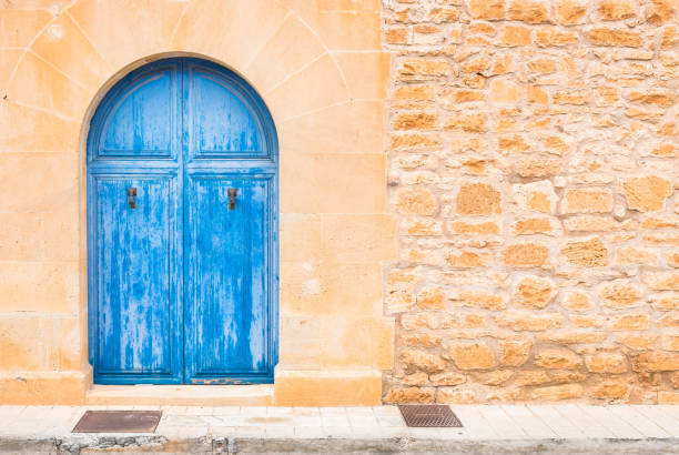 istock Mediterranean house blue front door with stone wall background 960839304