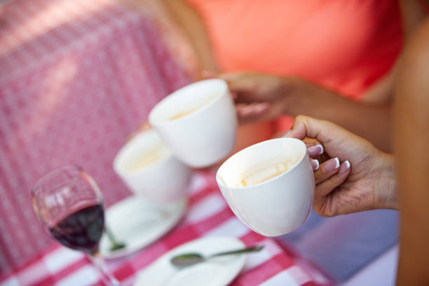 Close-up of friends drinking coffee outdoors
