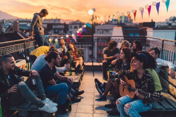 istock Friends drinking beer and playing the guitar on rooftop party 960850948
