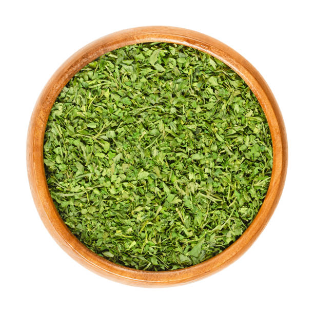 istock Dried parsley in wooden bowl over white 960852576
