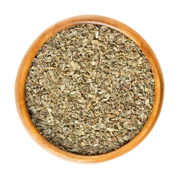 istock Dried basil leaves in wooden bowl over white 960852578
