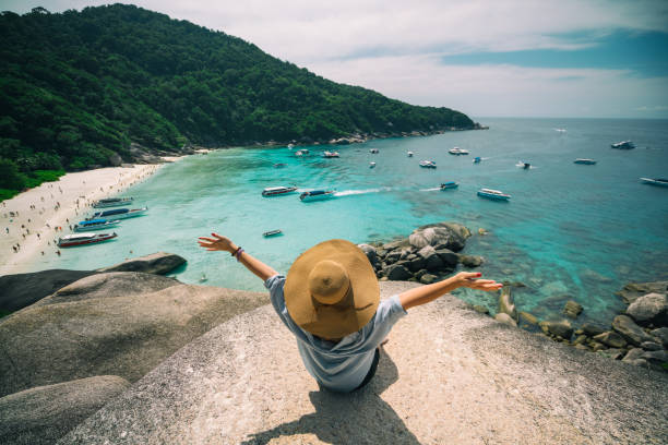 Summer concept Rear view of young woman traveler with hat sitting and relaxing on viewpoint at similan islands in Andaman sea at Phang Nga province near Phuket and Krabi in southern of Thailand. Summer Relax phuket province stock pictures, royalty-free photos & images