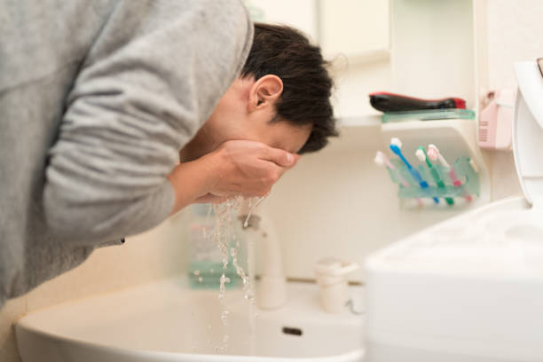istock man washing face in wash room 960858690