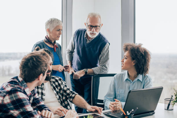 istock Elderly businessman talking with coworkers at office 960866082