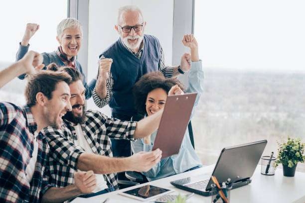 istock Ecstatic coworkers raising arms and looking at paperwork 960866186