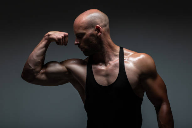istock Attractive male body builder flexing his biceps muscles in studio shot. Concept Gym Life Style. 960867732