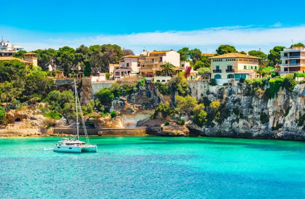 Beautiful view of bay with sailing boat at the seaside of Porto Cristo on Mallorca, Spain Mediterranean Sea