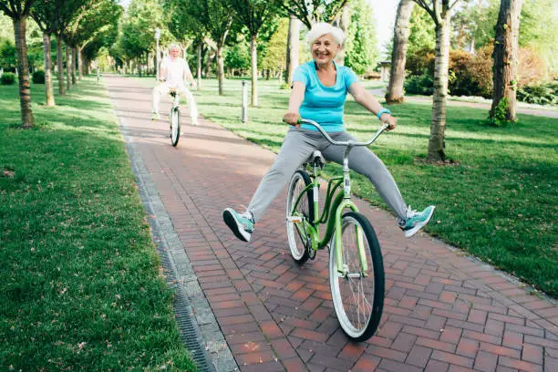 Photo of elderly woman having fun cycling