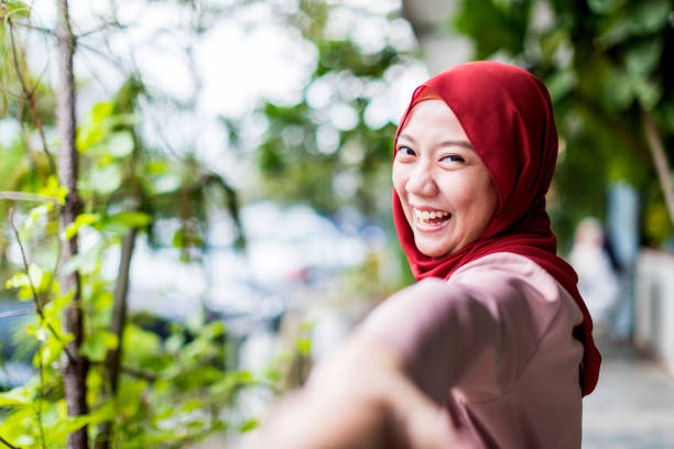 istock Married woman leading her husband down the park 960879978