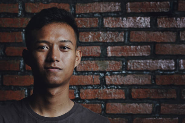 istock Close up of Asian Man on Brick Wall Background 960880612