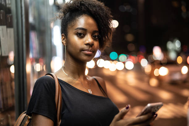 istock Young black woman using mobile in urban background 960881498
