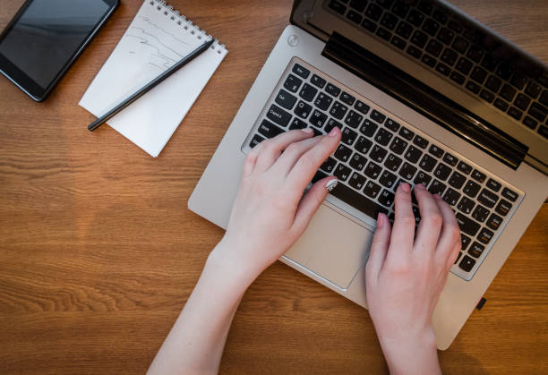 istock Girl hands type text notebook top view typing. Background lies notepad with pen and smartphone. The concept of business, for work, success, office, communication, technology 960891744