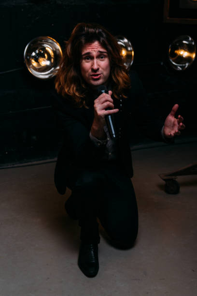 istock Brutal singer with long hair, with microphone on the stage 960902850