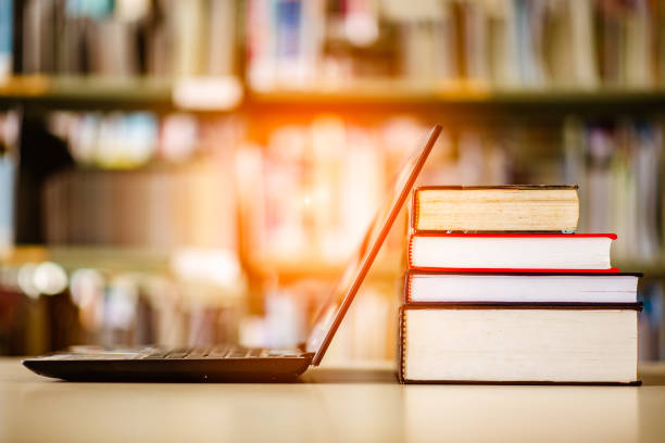 istock Bookshelves and laptops are placed on the library desk. 960910962