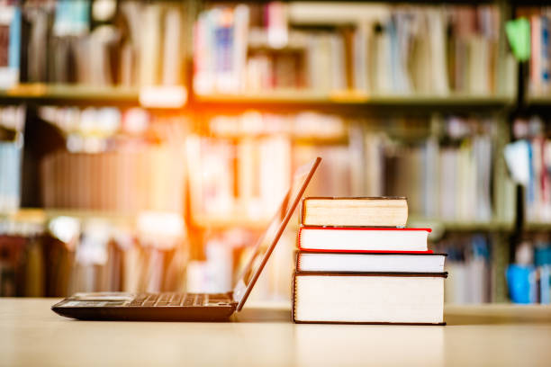 istock Bookshelves and laptops are placed on the library desk. 960910968