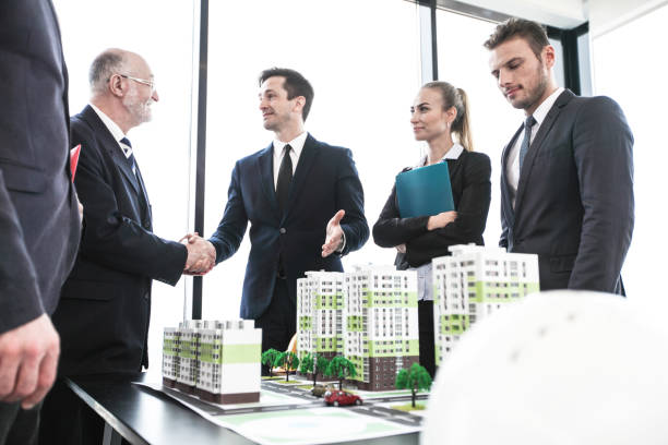 istock Business people standing near houses models 960917192