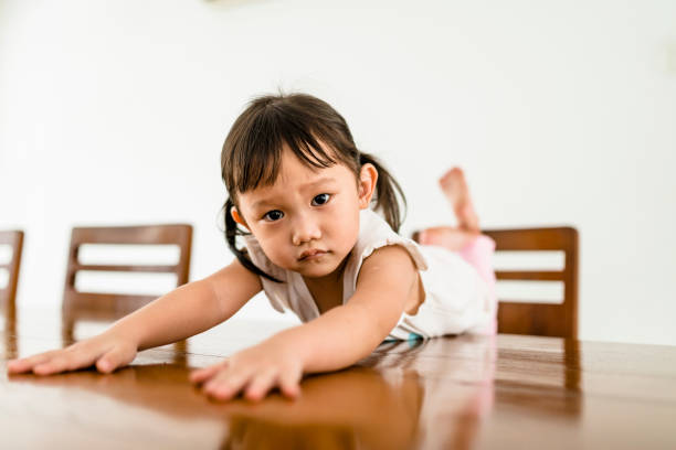 istock Young chinese girl lying on the kitchen table 960926828