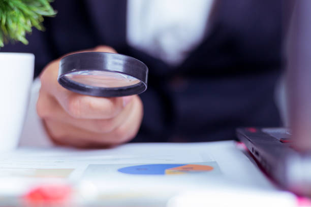 istock Business Analysis and Statistics Reports from sales charts last year using a magnifying glass. 960931816