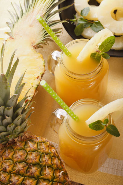 istock Delicious fresh pineapple juice in a glass jar closeup. vertical 960932034