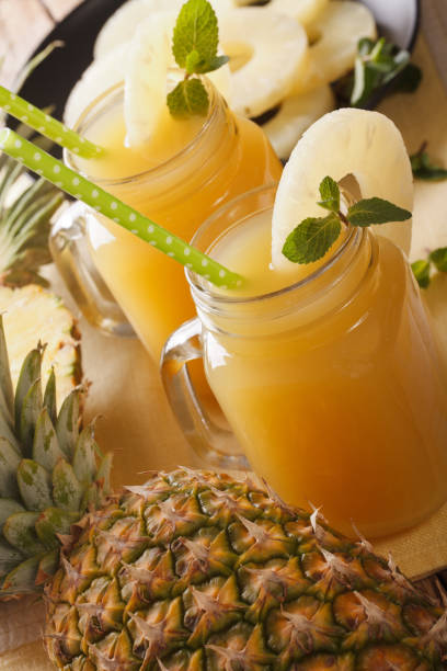 istock Fresh pineapple juice in a glass jar macro. vertical 960933056