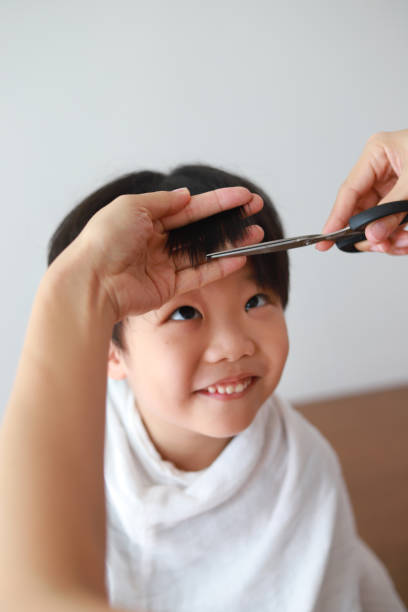 istock Mother giving son haircut 960936998