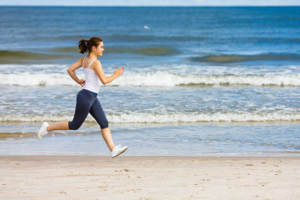 istock Young woman running on beach 960942286