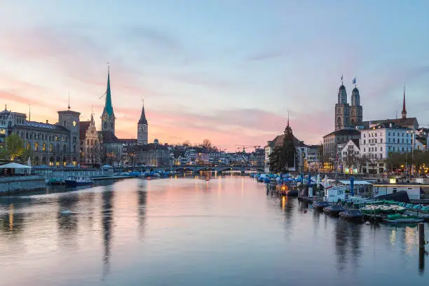 Classic views of the Zurich skyline at long the Limmat river at sunset. The Grossmünster, Fraumünster and St. Peter Church can be seen.