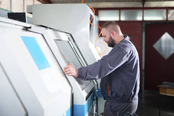 istock Man working on CNC machine in factory 960949860