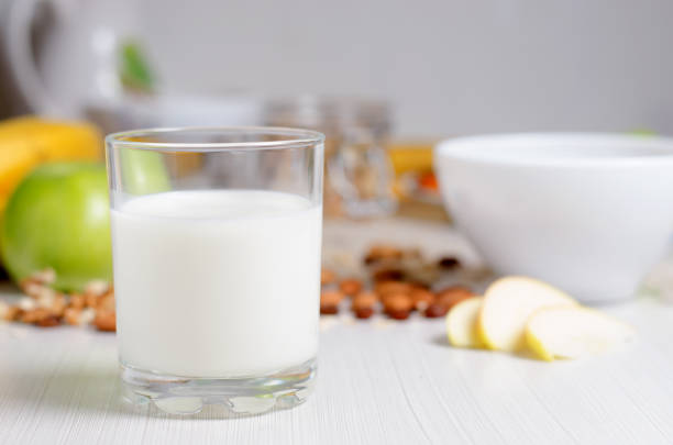 colazione sana. latte in un bicchiere. frutta, noci su un tavolo bianco. - oatmeal raisin porridge nut foto e immagini stock