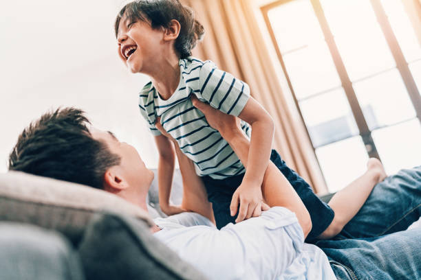 istock Father lifting his son, playing at home 960963952