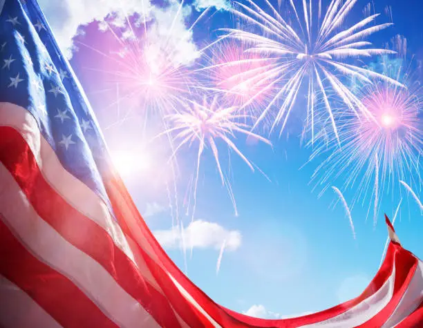 Usa Flag Against Sunny Sky With Fireworks