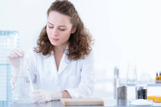 Biotechnologist dissolving sample in solution Biotechnologist dissolving the sample in solution during laboratory analysis colloid stock pictures, royalty-free photos & images