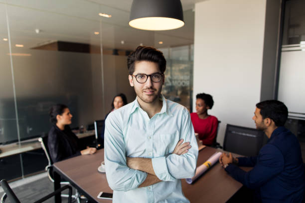 istock Young man sitting on table in front of colleagues 960981266