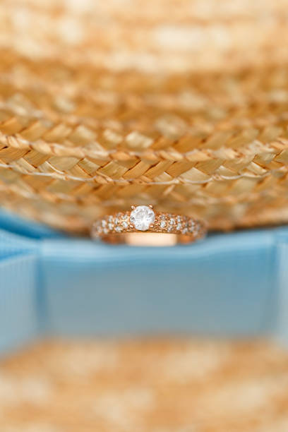 istock Golden engagement ring with diamonds lying on the canotier hat 960986336