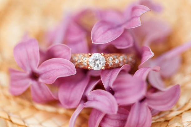 istock jewelry engagement ring with diamonds and spring lilac flowers 960988704