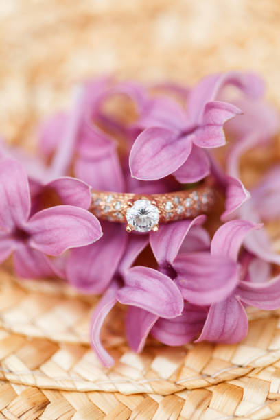 istock jewelry engagement ring with diamonds and spring lilac flowers 960989156