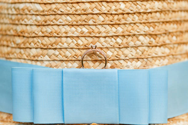 istock Golden engagement ring with diamonds lying on the canotier hat 960989354