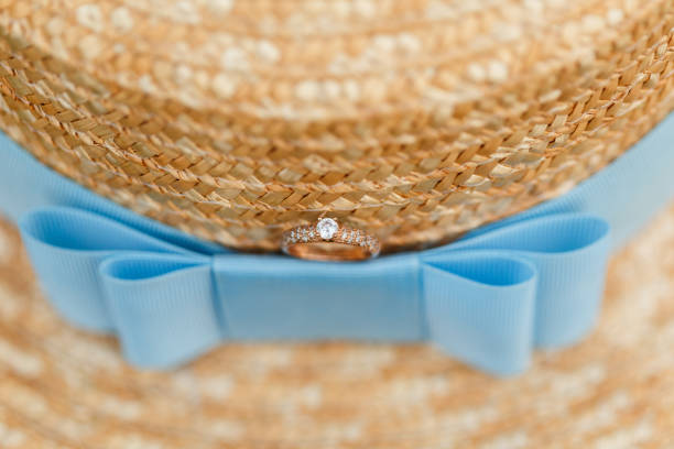 istock Golden engagement ring with diamonds lying on the canotier hat 960989400