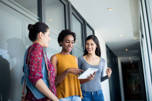 istock Young women standing in hallway and looking at digital tablet 961007326