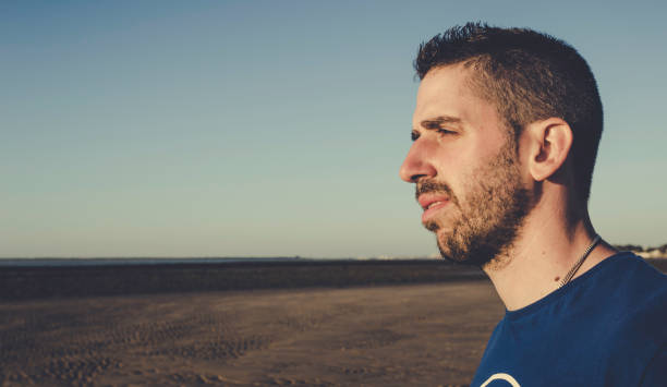 istock Young man sideways looking to the beach in Sanlucar de Barrameda 961008100