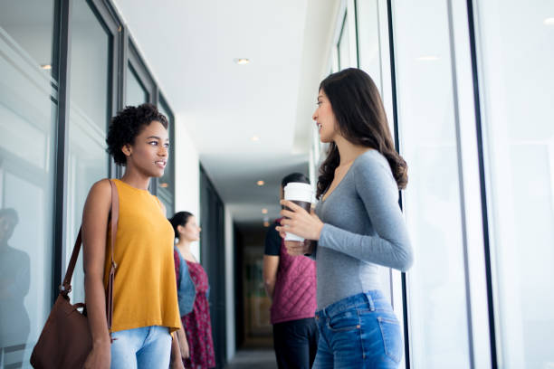 istock Two female colleagues standing in hallway and talking 961008340