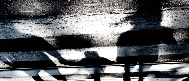 Blurry abstract shadow silhouette of family with a child on crossroads in black and white